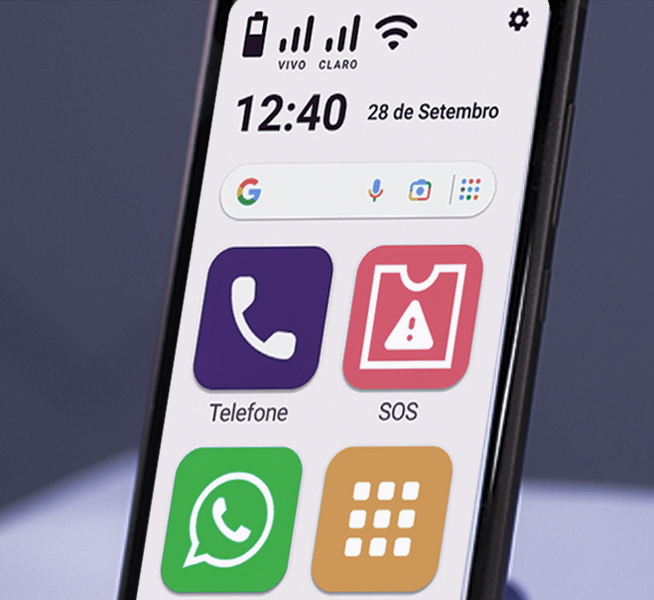 A imagem exibe a tela de um smartphone, mostrando a barra de status com os ícones das operadoras Vivo e Claro, sinal de Wi-Fi e bateria. Há quatro aplicativos na tela inicial: Telefone, SOS, WhatsApp e um ícone de teclado numérico, todos com ícones grandes, possivelmente para facilitar o uso por pessoas com dificuldade visual ou idosos. A data "28 de Setembro" e o horário "12:40" também são mostrados.