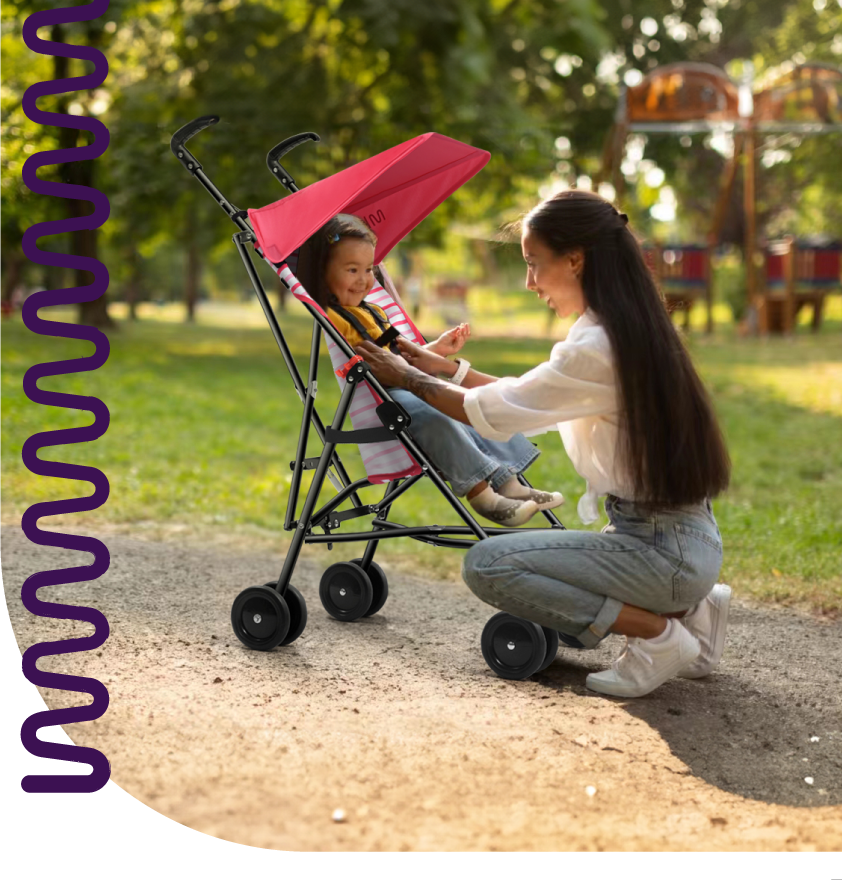 Uma mulher segura um bebê em um carrinho.