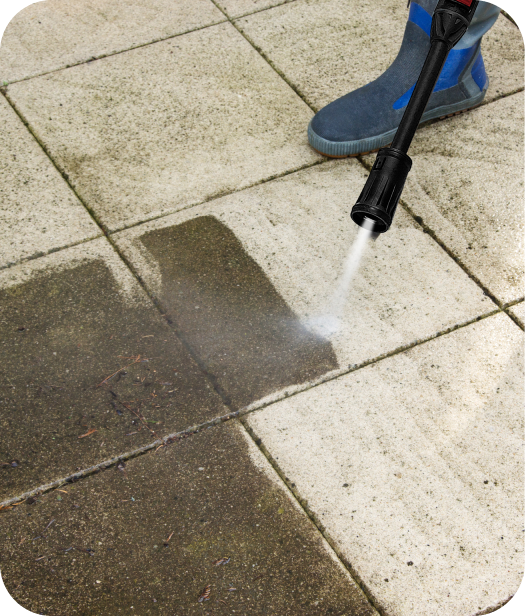 Uma pessoa usando uma lavadora de alta pressão para limpar um azulejo