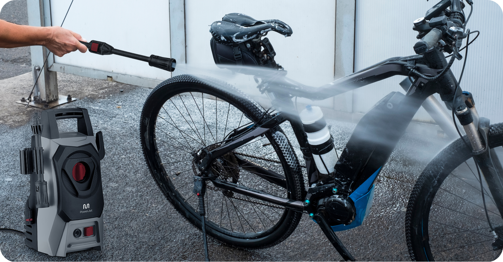 Pessoa usando uma lavadora de alta pressão para limpar uma bicicleta