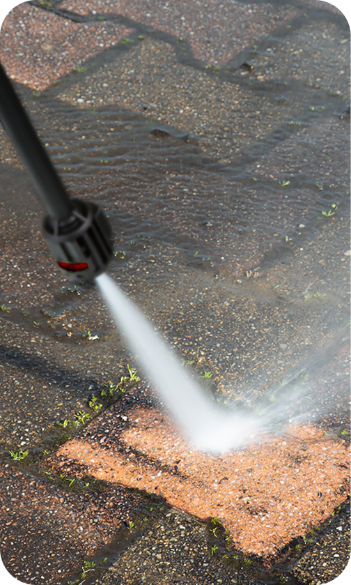 Homem limpando calçada com lavadora de alta pressão