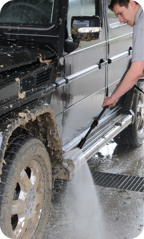 Homem limpando carro com lavadora de alta pressão