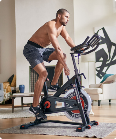 Foto de um homem se exercitando na Bike Spinning Schwinn.