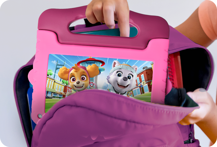 Foto de uma criança colocando o Tablet Patrulha Canina Skye em uma mochila, segurando pela alça do próprio tablet, que é fácil e seguro de transportar.