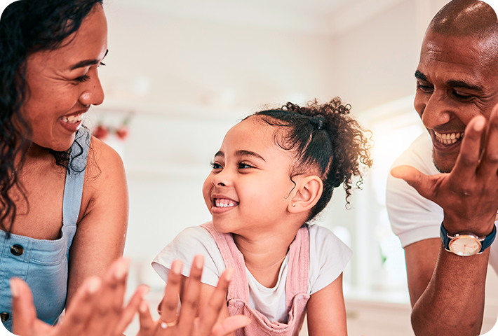 Foto de uma família feliz reunida: mãe, filha e pai.