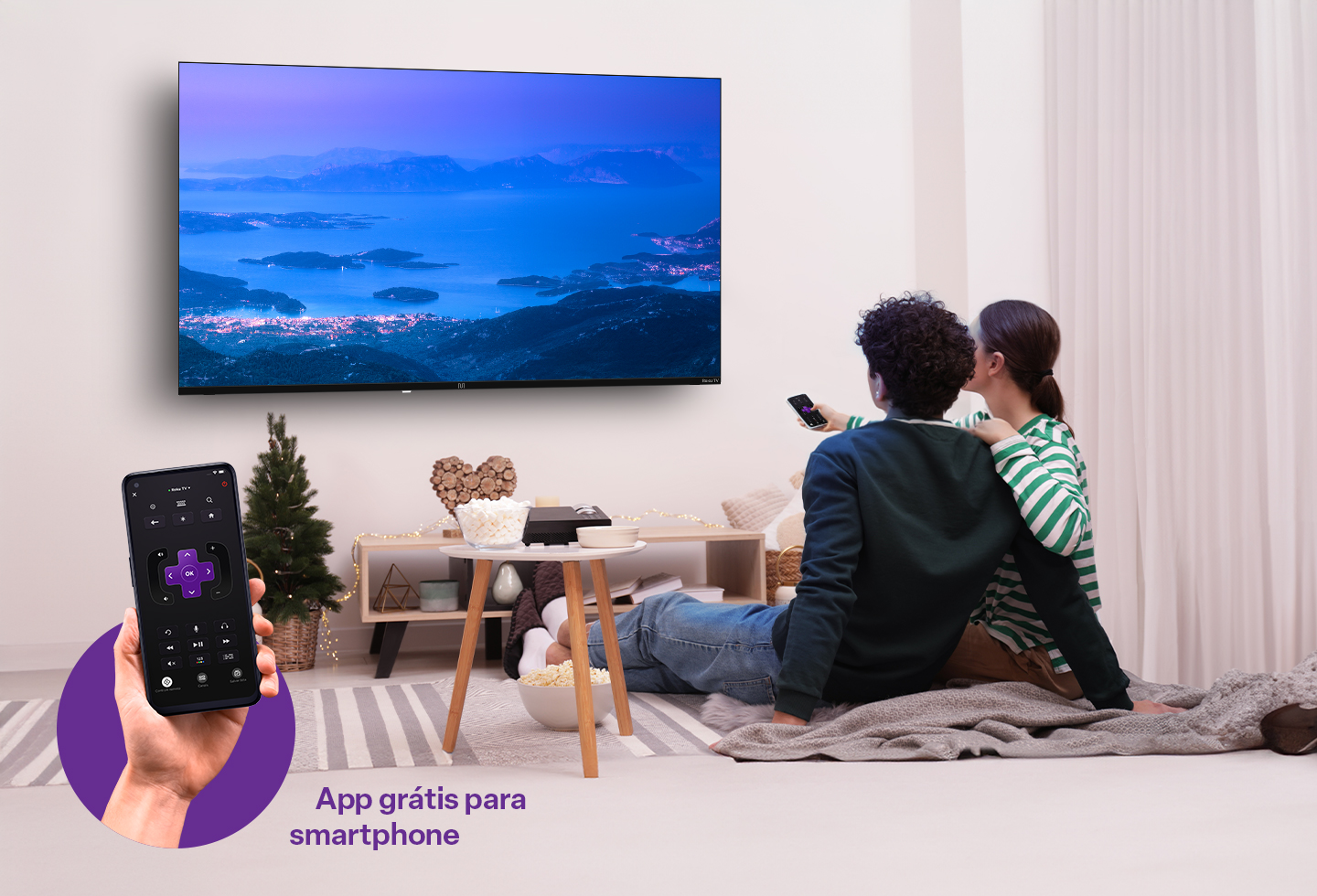 Foto de um casal de frente para uma TV, ambos sentados em uma cama e com olhar fixo para a televisão