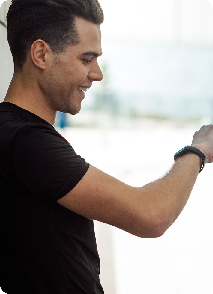 Homem de camisa preta olhando para seu SmartWatch em seu braço