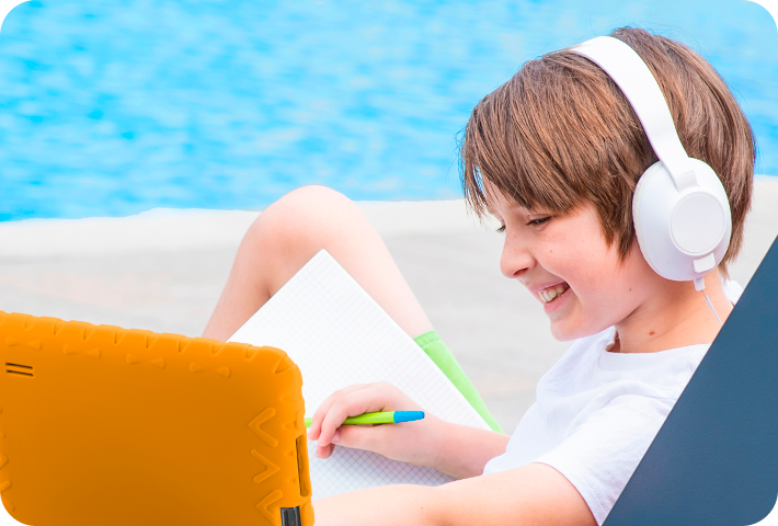 Criança sorridente usando o Tablet Kid Pad Laranja.
