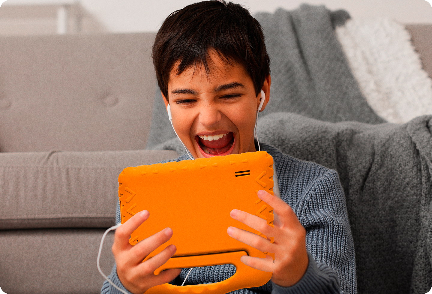 Foto de um garoto se divertindo mexendo no Tablet Kid Pad Laranja.