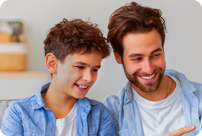 Imagem de pai e filho olhando fixo para o Tablet Kid Pad na mão do próprio pai.