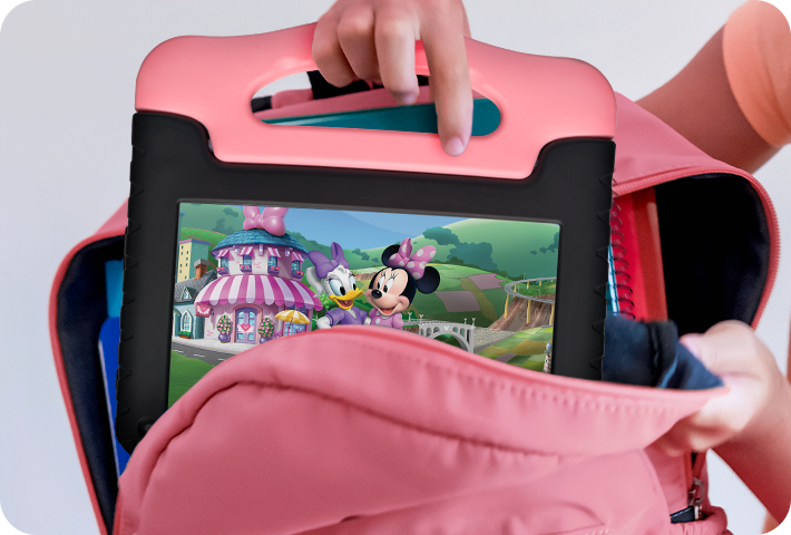Foto de uma criança colocando o Tablet Minnie em uma mochila, segurando pela alça do próprio tablet, que é fácil e seguro de transportar.