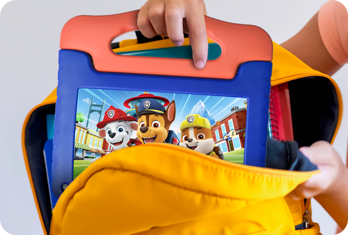 Foto de uma criança colocando o Tablet Patrulha Canina Chase em uma mochila, segurando pela alça do próprio tablet, que é fácil e seguro de transportar.