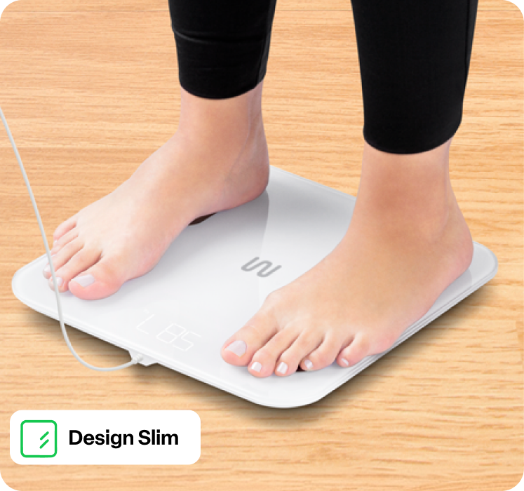 Pessoa em cima da balança Bio Health Pro, destaque para o design slim